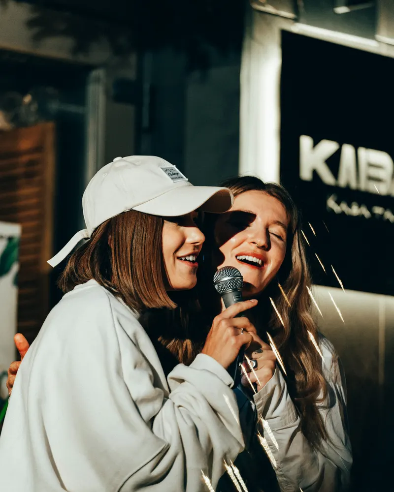 Zwei Freundinnen singen zusammen Karaoke